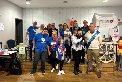 A photo of a large group of people wearing Christie Charity t-shirts and sashes.