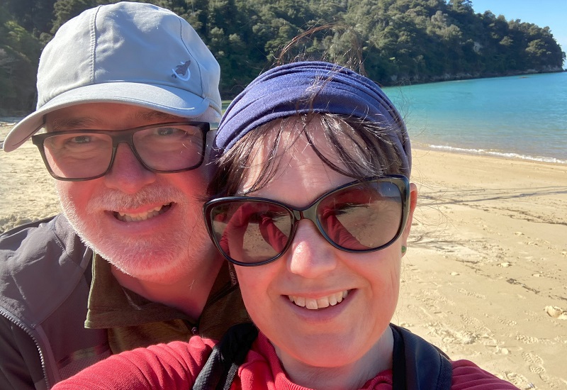 A photo of Christie patient Duncan Edmonstone with his wife Kay on a beach in New Zealand.