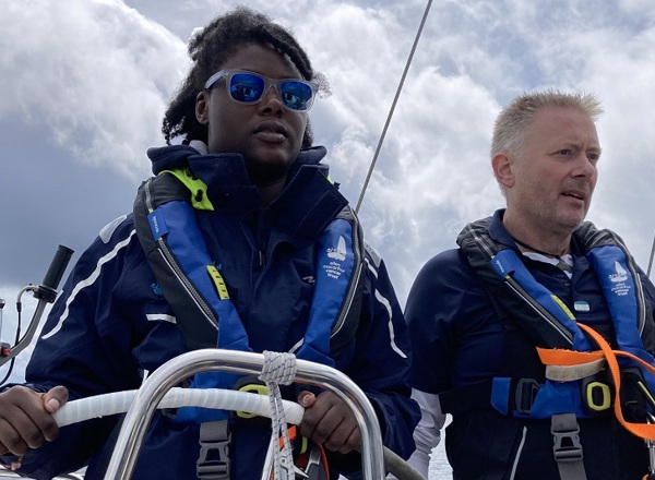 A photo of Christie patient Mercy wearing sunglasses and steering a boat.