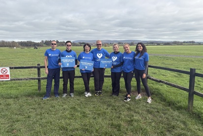 A photo of a team from Pareto wearing Christie Charity t-shirts and standing in a field.