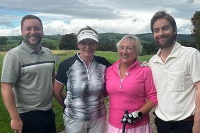 A photo of 2 female golfers and 2 male golfers.