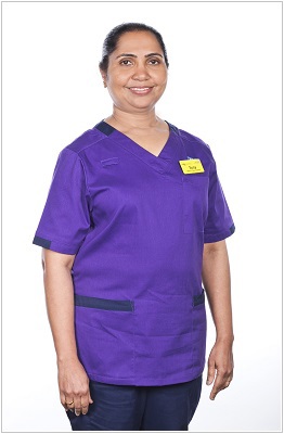 A photo of a matron wearing a uniform in purple with navy trim.