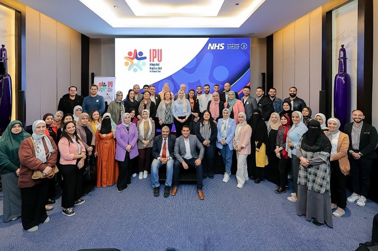 A photo of a training event at the Egypt Healthcare Authority, showing a large group of people stood around in an arc.
