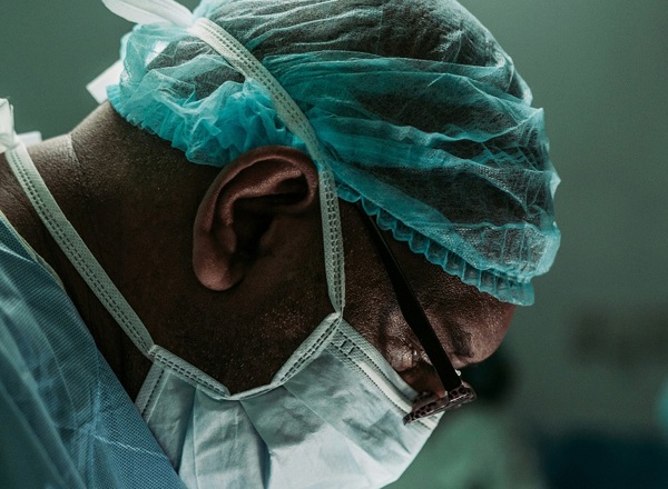 A close-up photo of a surgeon in a surgical mask.