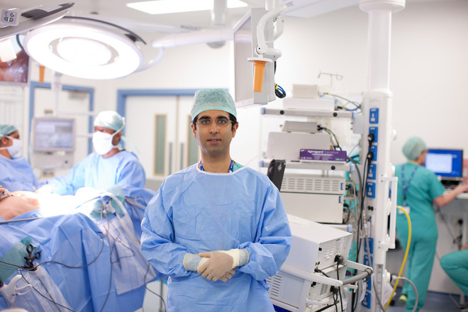A photo of Christie consultant Professor Omer Aziz in theatre, surrounded by people carrying out surgery.
