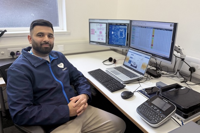 A photo of Aamir Hussain from The Christie IT team sitting in front of a computer screen.