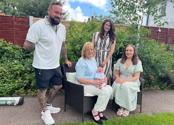 A photo of Christie patient Ann Lally, her adult children Becky and Michael, Michael's wife and their newborn baby Arthur.