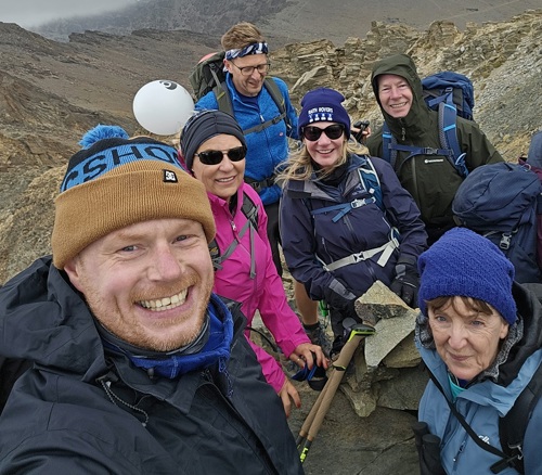 A photo of a group of trekkers on top of a mountain.