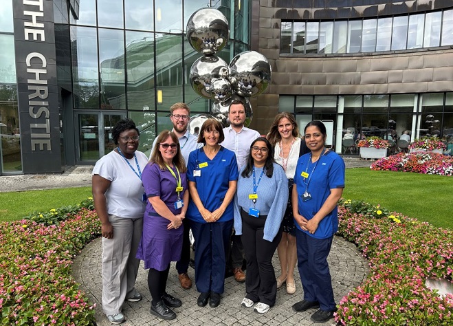 A photo of the pan tumour research team standing outside the front of The Christie.