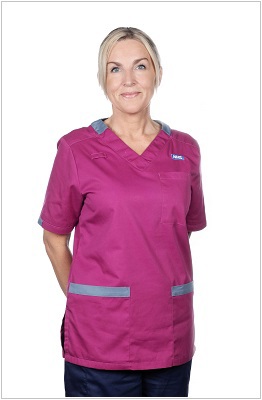 A photo of a speech and language therapist wearing a uniform in ruby with bright blue trim.
