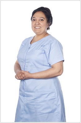A photo of nursing associate wearing a uniform in sky blue with matching sky blue trim.