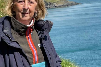 A photo of Christie patient Bernadette Smith standing on a cliff.