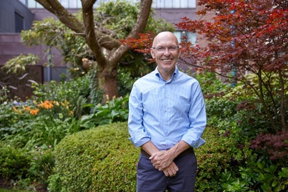 A photo of Christie patient John McGartland standing in the garden at The Christie.
