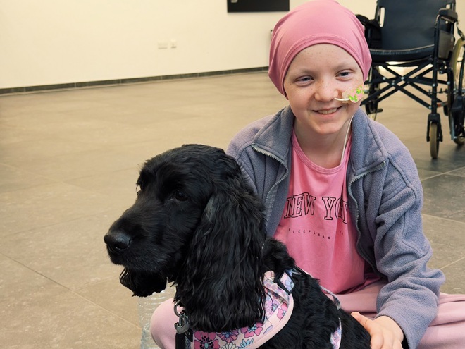A photo of Christie patient Jaye with Lilo the black spaniel.